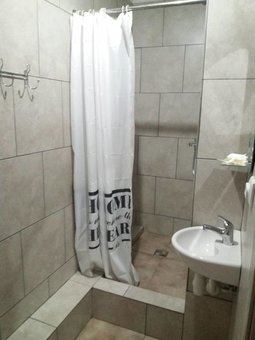 A bathroom with a shower in a standard room at the Central Park hotel in Lviv. Register for a discount.